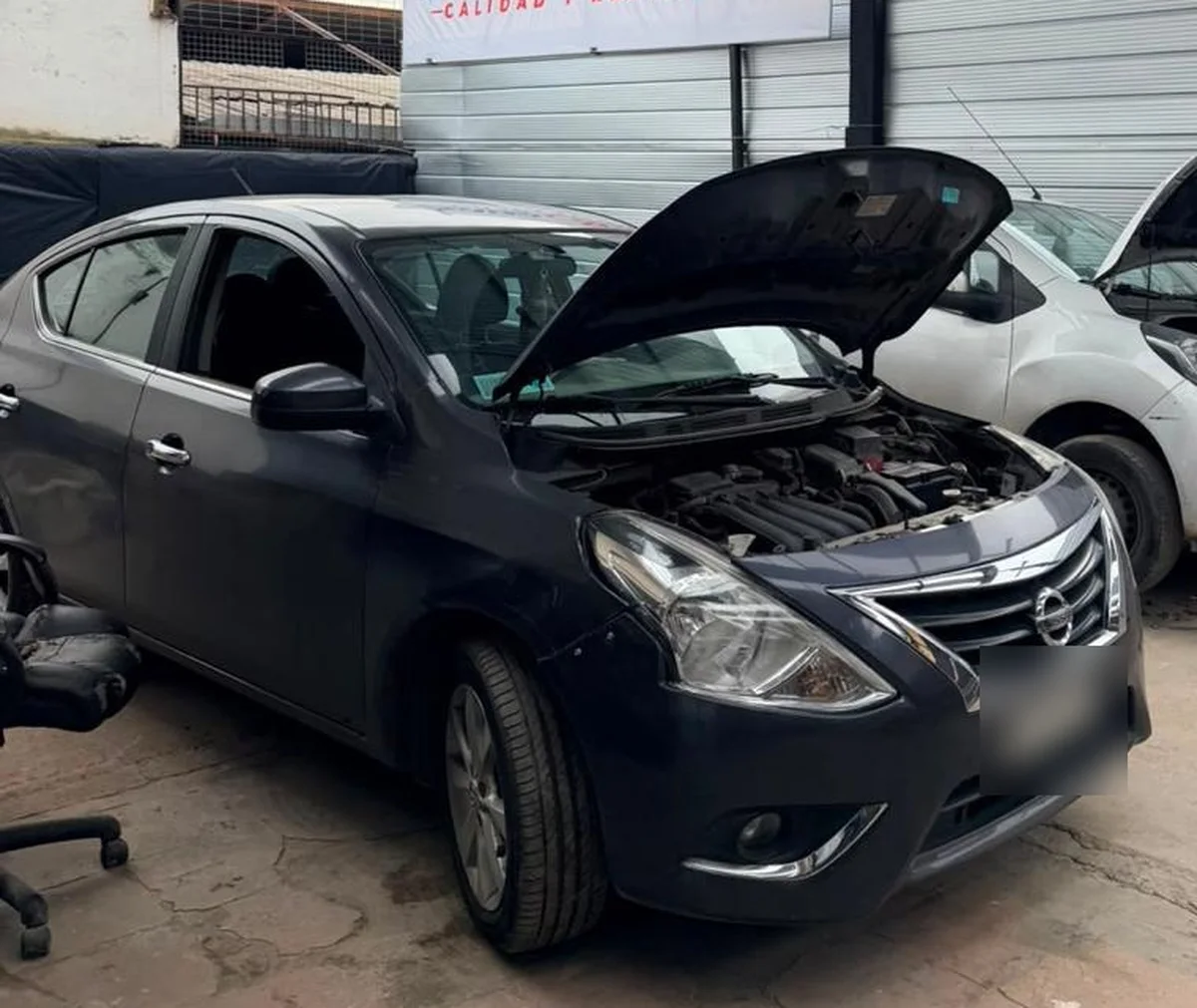 Auto con el capó abierto en el taller Isadacar, listo para la inspección
